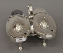 A silver plated cruet stand and a double serving dish
