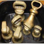 A collection of brass bell weights. The largest 18.5 cm high.