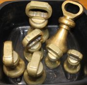 A collection of brass bell weights. The largest 18.5 cm high.