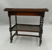 An early 20th century oak barley twist folding tea trolley/games table. 77.5 cm wide.