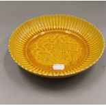 A Chinese yellow porcelain plate. 22 cm diameter.