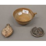 A Roman clay oil lamp of typical form,