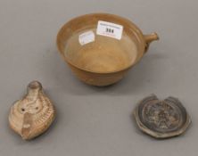 A Roman clay oil lamp of typical form,