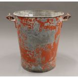 A vintage red painted fire bucket.