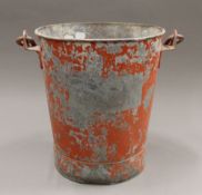 A vintage red painted fire bucket.