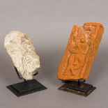 An antique Indian terracotta panel Figurally carved; together with a carved stone head,