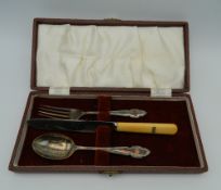 A cased silver and silver plate Christening set, together with a cake knife. The latter 29 cm long.