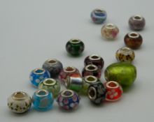 Twenty silver and glass charms. The largest 2 cm wide.