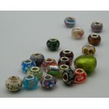 Twenty silver and glass charms. The largest 2 cm wide.