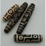 Four agate dzi beads. The largest 7.5 cm long.