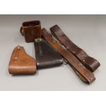 Two military belts, two gun holsters and a binoculars case.