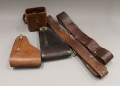 Two military belts, two gun holsters and a binoculars case.