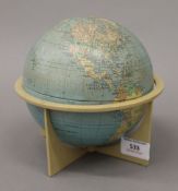 A small Phillips tin plate globe, on stand. 16 cm high.