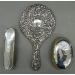 A silver hand mirror and two silver brushes. The former 28 cm high.