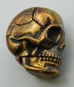 A brass vesta formed as a skull. 4 cm high.