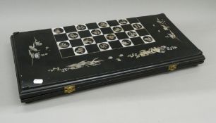 An early 20th century carved horn and ivory chess and backgammon set,