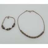 A silver necklace and bracelet set. The former 41 cm long. 33.6 grammes.