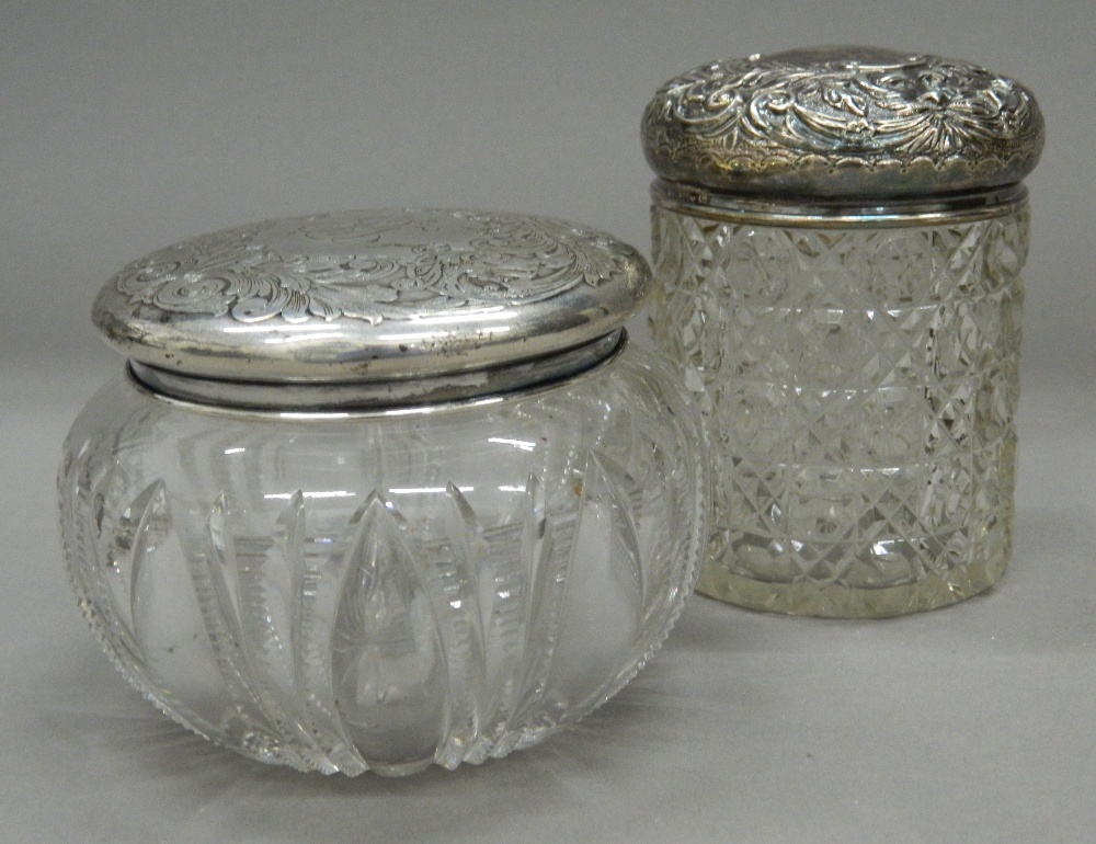 Two silver topped dressing jars. The largest 10.5 cm high.