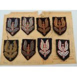 A collection of SAS (Special Air Service) beret cloth patches mounted on card,