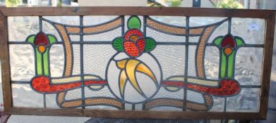 An Art Nouveau leaded stained glass panel. 102 cm wide.