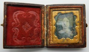 A small leather cased daguerreotype portrait of a girl. 5 cm high.