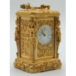 A miniature carriage clock with figural decorated case. 8.5 cm high.