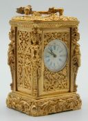 A miniature carriage clock with figural decorated case. 8.5 cm high.