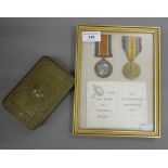 A framed pair of WWI medals awarded to Pte E Fuller of the Suffolk Regiment, a Princess Mary tin,