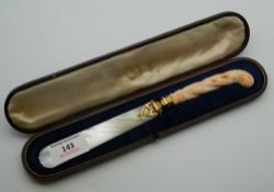 A Victorian cased carved coral handled silver gilt mounted and mother-of-pearl letter opener. 23.