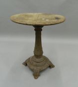 A Victorian oak topped cast iron garden table. 75 cm high.