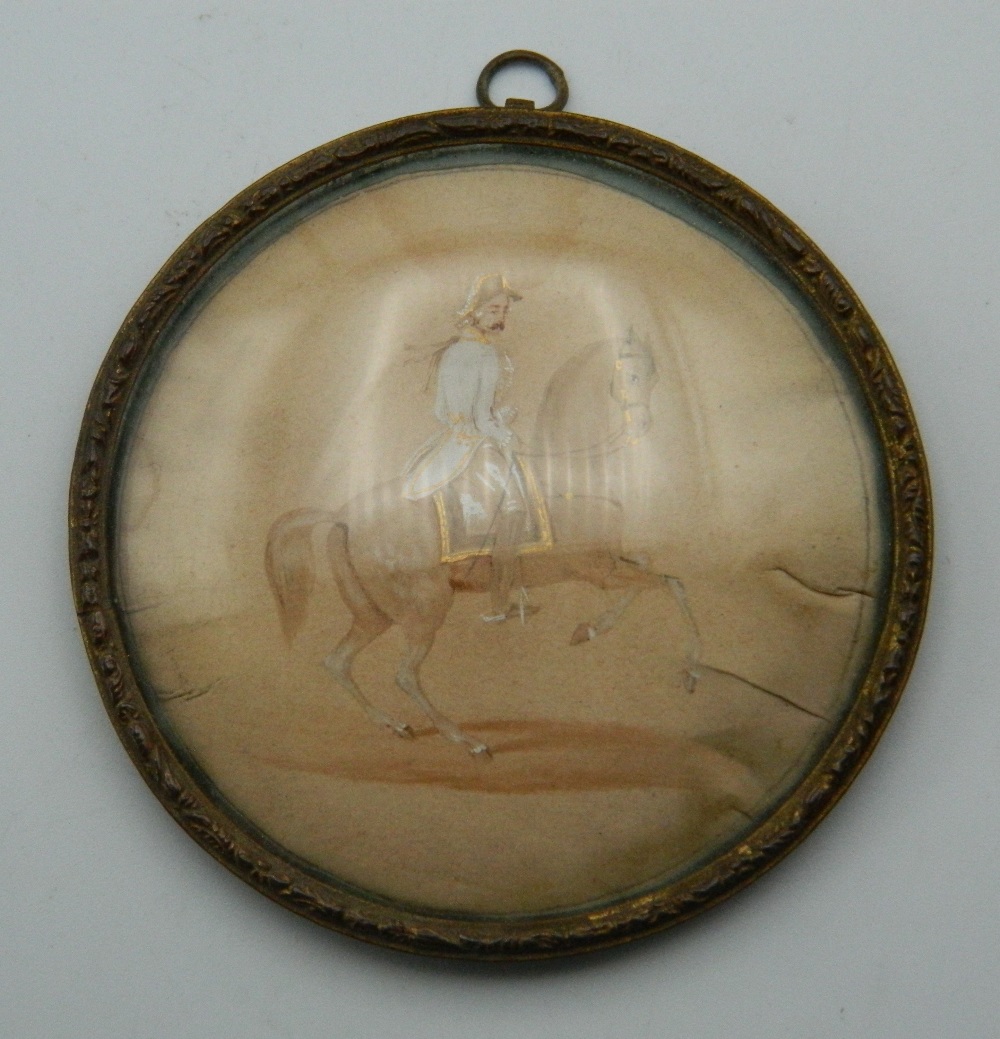 A 19th century framed miniature depicting a soldier on horseback. 7 cm diameter.
