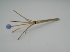 A 9 ct gold champagne swizzle stick. 8.4 grammes total weight.