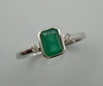 A 9 ct white gold emerald and diamond three stone ring. Ring size O/P.