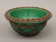 A 19th century Chinese pottery bowl with basket weave outer covering. 18.5 cm diameter.