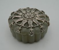 A silver mounted jade box, bearing Russian marks. 5.5 cm diameter.