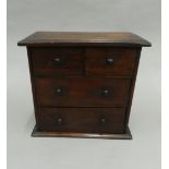 A miniature oak chest of drawers. 35 cm wide.