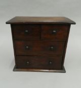 A miniature oak chest of drawers. 35 cm wide.