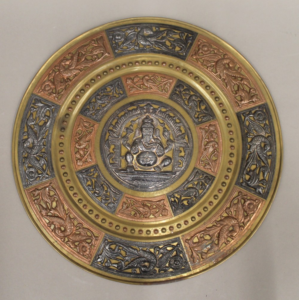 An Indian unmarked white metal copper set brass plaque. 35.5 cm diameter.