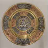 An Indian unmarked white metal copper set brass plaque. 35.5 cm diameter.