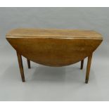 A 19th century French cherrywood drop leaf table. 135 cm long.