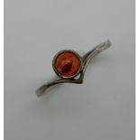 An amber set unmarked silver ring. Ring Size O/P.