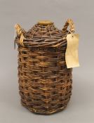 A Royal Navy wicker clad stoneware flagon, full and sealed, with supply depot label. 34 cm high.