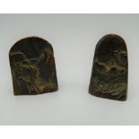 Two bronze seals decorated with mountainous scenes. The largest 4.5 cm high.
