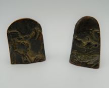 Two bronze seals decorated with mountainous scenes. The largest 4.5 cm high.