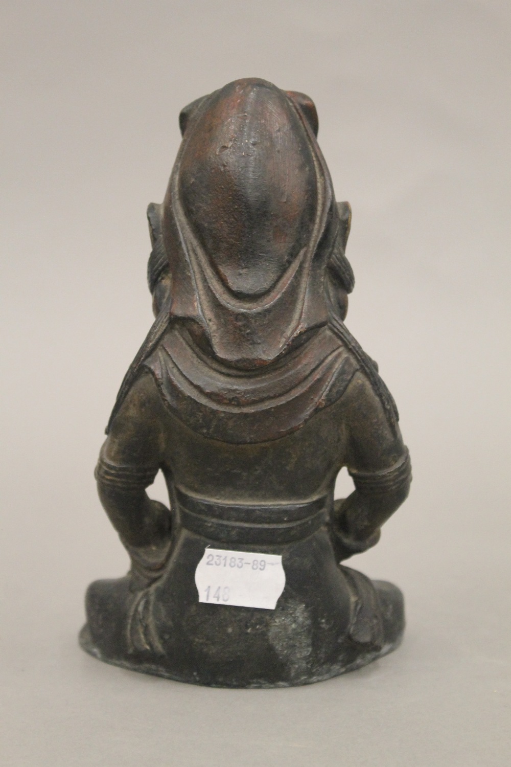A seated bronze deity holding a teapot. 18 cm high. - Bild 3 aus 4