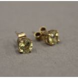 A pair of 9 ct gold and peridot ear studs. 5 mm diameter.