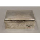 A silver cigarette box. 14 cm wide. 17.8 troy ounces total weight.