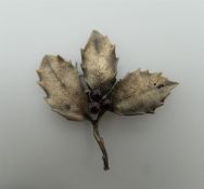 A silver brooch formed as a holly leaf. 6 cm wide.