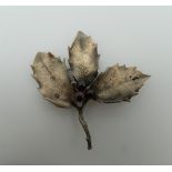 A silver brooch formed as a holly leaf. 6 cm wide.