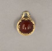 A 9 ct gold and agate fob. 2 cm high.